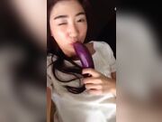 Asian girl fucking herself with an eggplant